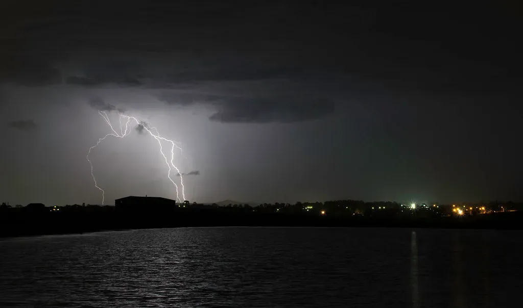 Lightning strikes over water during a night storm